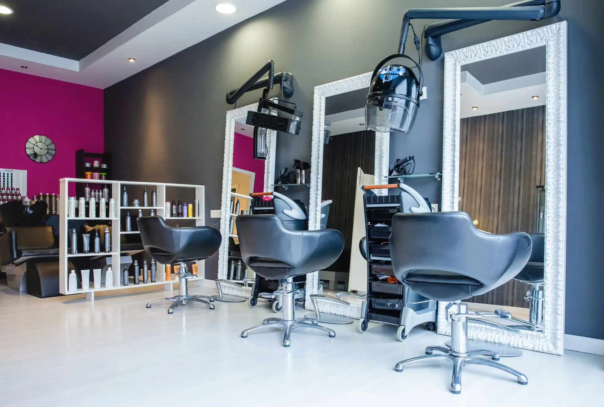 Modern hair and beauty salon interior featuring three styling chairs, large mirrors, and product shelves, emphasizing a sleek and organized space for enhanced client experiences.